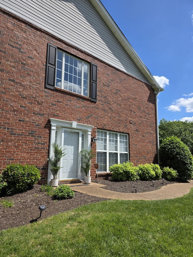 view of front of home with brick siding and a front yard