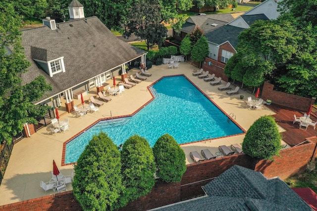 community pool with fence and a patio area