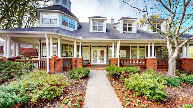 view of front facade featuring a porch, french doors, and a shingled roof