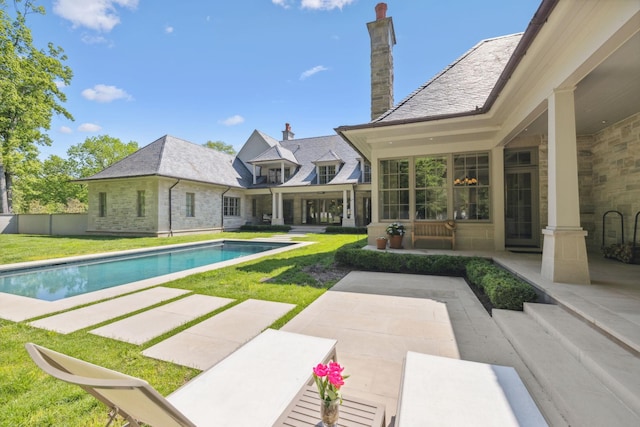swimming pool featuring a patio area and a yard