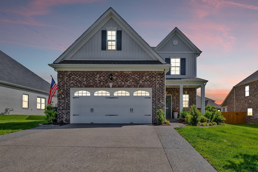1013 Wickshire Dr, Gallatin, TN 37066 - traditional home with board and batten siding, concrete driveway, brick siding, and a porch