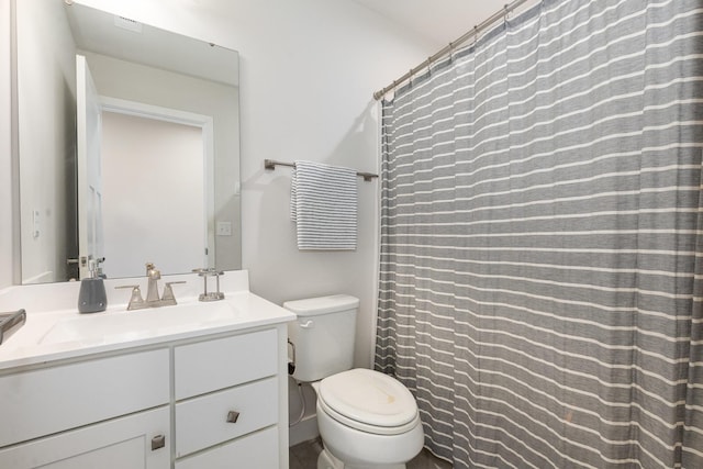 bathroom with toilet, vanity, and curtained shower