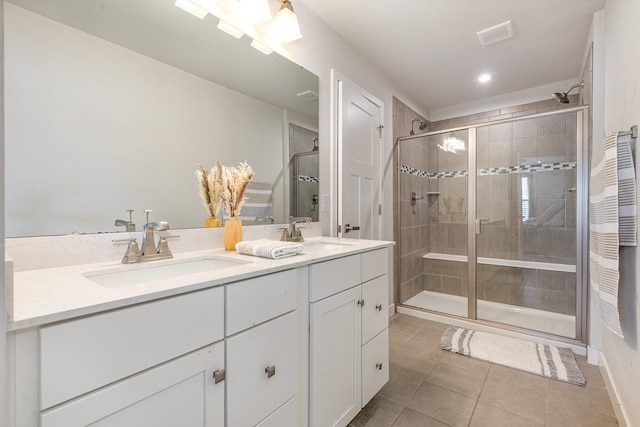 bathroom with a shower stall, tile patterned flooring, double vanity, and recessed lighting