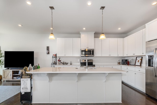 kitchen featuring stainless steel appliances, a sink, light countertops, a breakfast bar area, and recessed lighting
