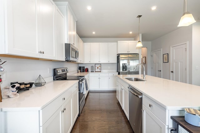 kitchen featuring appliances with stainless steel finishes, a sink, recessed lighting, white cabinets, and light countertops