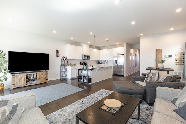 living area featuring dark wood finished floors, recessed lighting, and baseboards