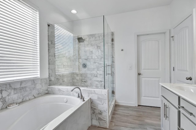 full bathroom featuring plenty of natural light, a stall shower, a bath, vanity, and recessed lighting