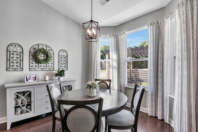 dining room featuring a chandelier, dark wood finished floors, and baseboards