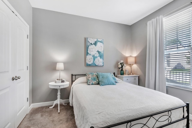 bedroom featuring light colored carpet and baseboards
