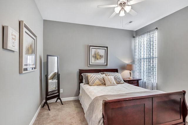 bedroom with light colored carpet, baseboards, and a ceiling fan