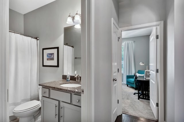 bathroom with vanity, toilet, curtained shower, and wood finished floors