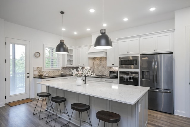 928 Tynan Way, Nolensville, TN 37135 - kitchen with stainless steel appliances, white cabinets, backsplash, dark wood-style floors, and a kitchen bar