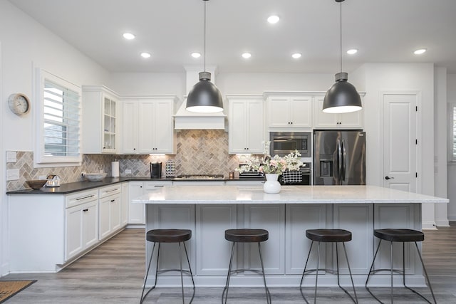 928 Tynan Way, Nolensville, TN 37135 - kitchen featuring stainless steel appliances, wood finished floors, a kitchen breakfast bar, a center island, and recessed lighting