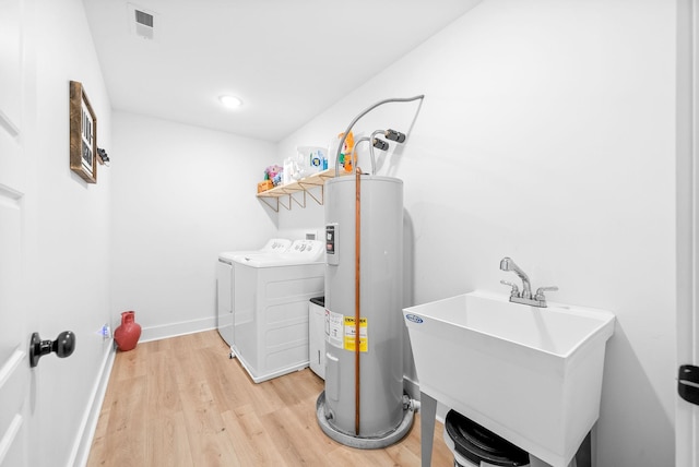 5921 Keysburg Rd, Adams, TN 37010 - washroom featuring water heater, washer and dryer, light wood finished floors, and baseboards