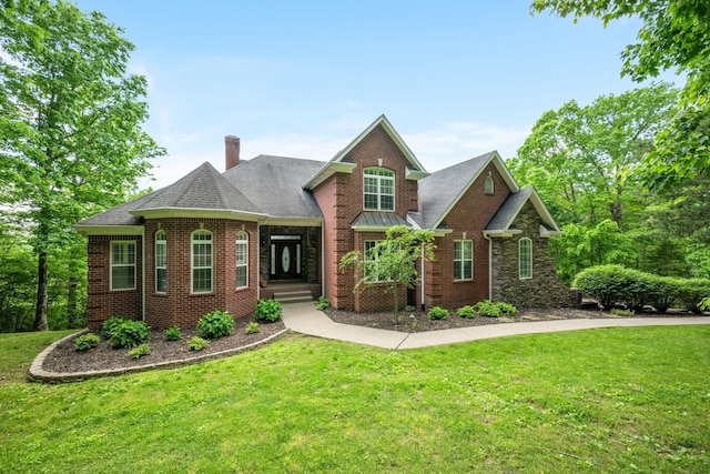 1709 Wildlife Trl, Kingston Springs, TN 37082 - view of front facade with a front lawn, a chimney, brick siding, and a shingled roof