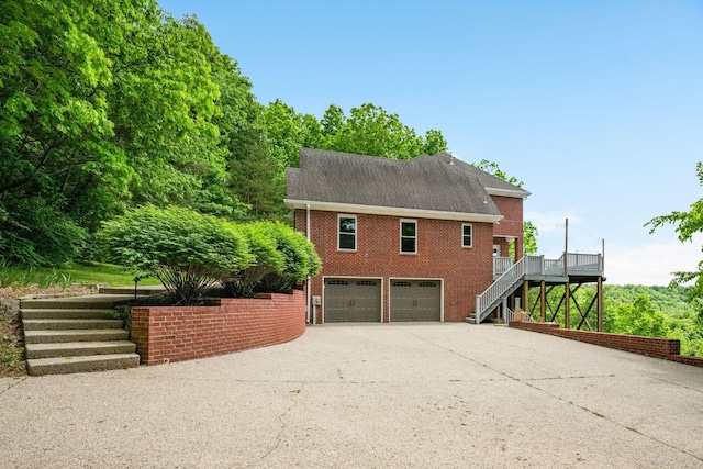 1709 Wildlife Trl, Kingston Springs, TN 37082 - view of home's exterior featuring stairway, brick siding, driveway, an attached garage, and a deck