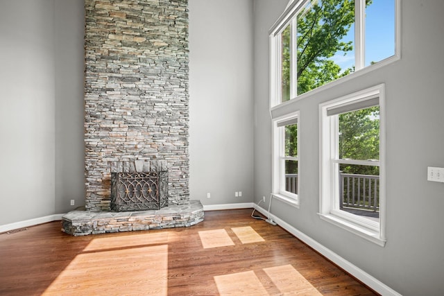 1709 Wildlife Trl, Kingston Springs, TN 37082 - unfurnished living room with healthy amount of natural light, a fireplace, wood finished floors, and a towering ceiling