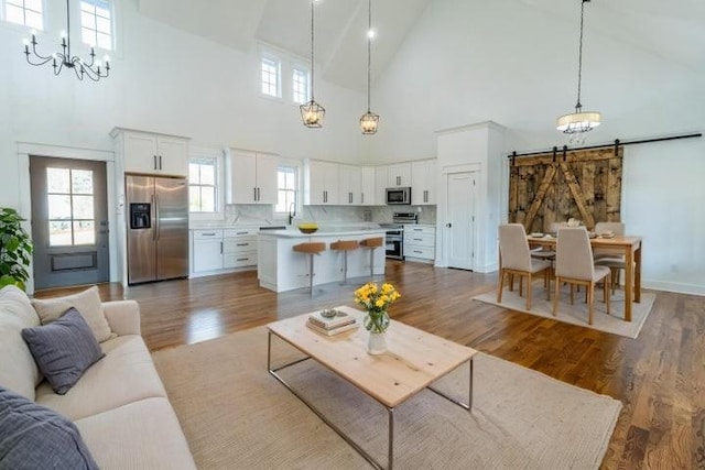 463 Waterfront Way, Ten Mile, TN 37880 - living area with high vaulted ceiling, a chandelier, a barn door, and wood finished floors