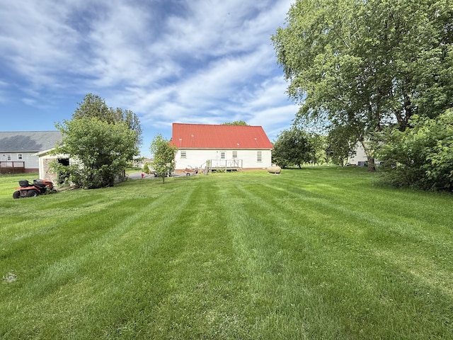 view of grassy yard featuring a deck
