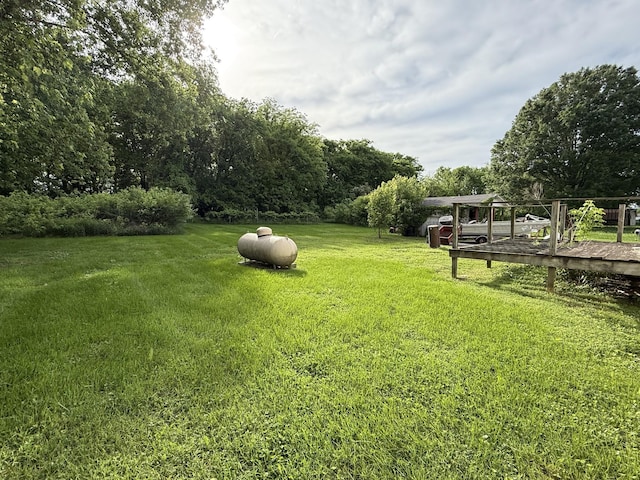 view of grassy yard featuring a wooden deck