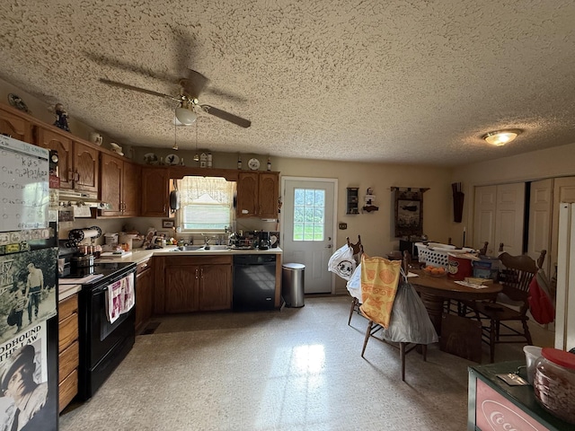 kitchen featuring black appliances, a sink, a ceiling fan, under cabinet range hood, and light floors
