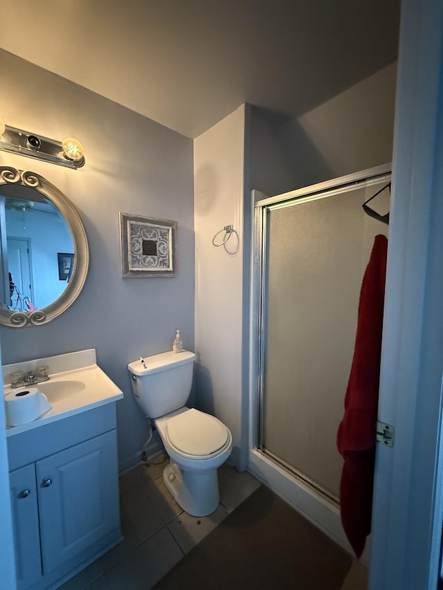 full bath with a stall shower, toilet, vanity, and tile patterned floors