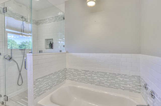 full bathroom featuring a bath and a shower stall