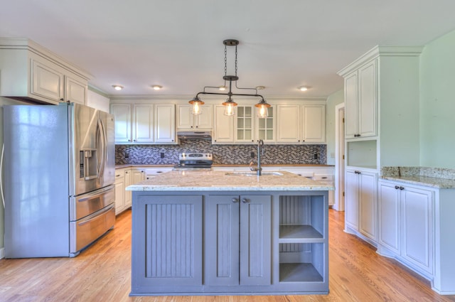 kitchen with stainless steel appliances, a sink, under cabinet range hood, open shelves, and backsplash