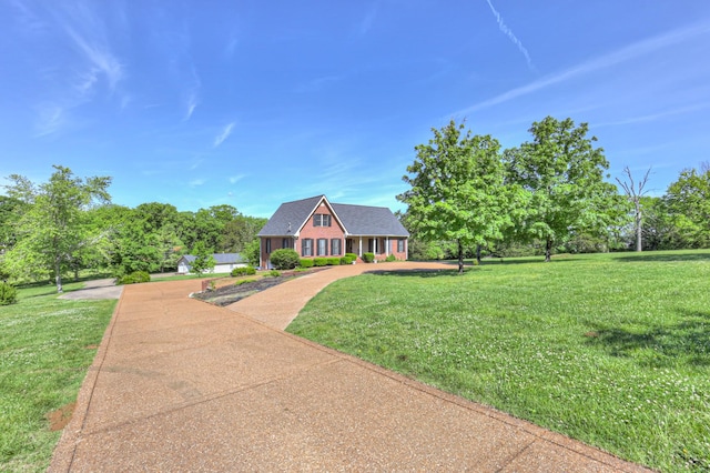 view of front of house featuring a front lawn, covered porch, and driveway