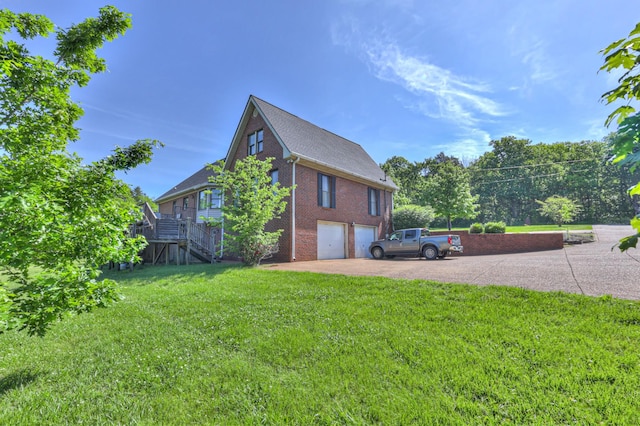view of property exterior with an attached garage, brick siding, driveway, stairs, and a yard