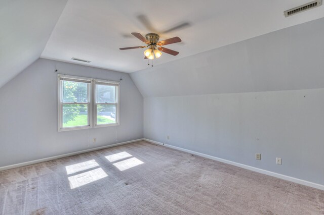 additional living space with lofted ceiling, carpet floors, a ceiling fan, and baseboards