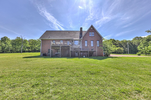 back of property with a deck, brick siding, a yard, and a chimney