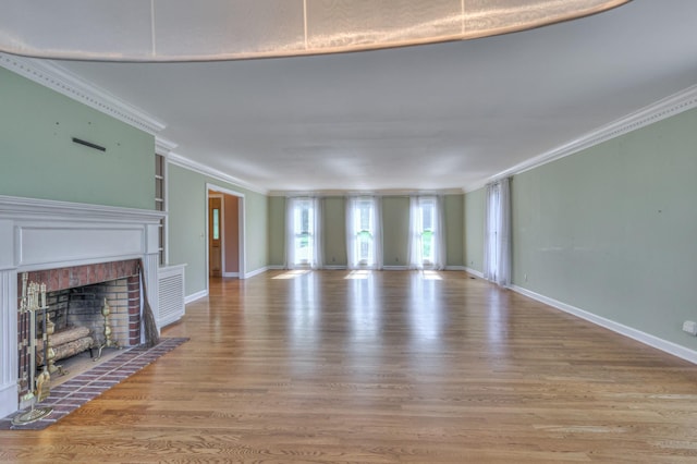 unfurnished living room with crown molding, wood finished floors, a fireplace, and baseboards
