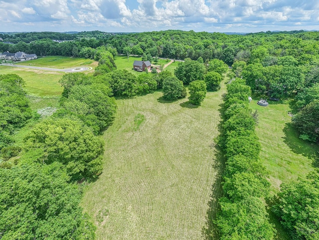 aerial view of property and surrounding area featuring a forest and rural landscape