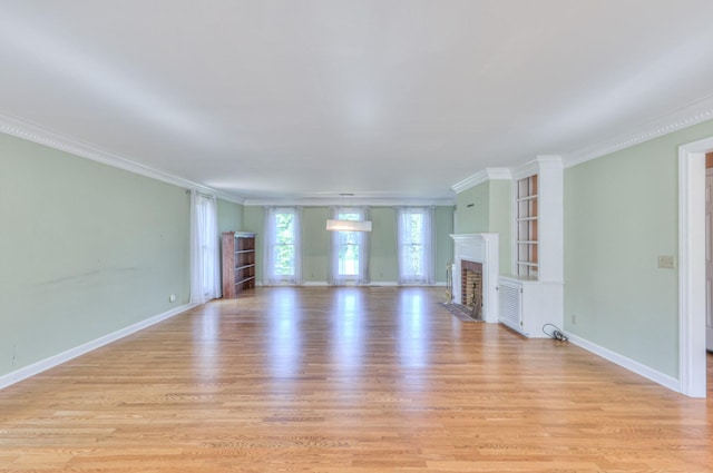 unfurnished living room with crown molding, light wood-type flooring, a fireplace with flush hearth, and baseboards