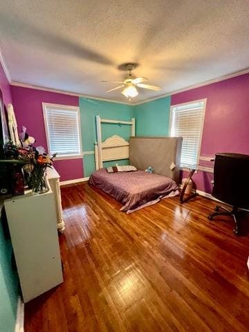 bedroom with a textured ceiling, crown molding, wood finished floors, ceiling fan, and baseboards