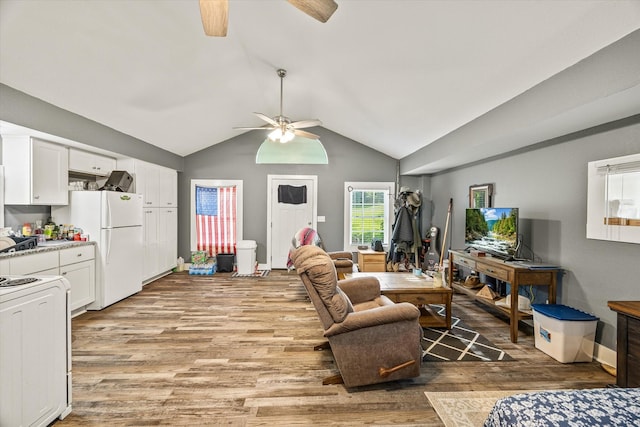 living room featuring a ceiling fan, light wood-style floors, and lofted ceiling