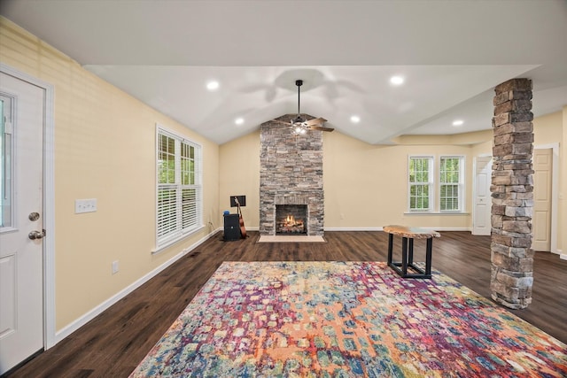 living room featuring decorative columns, wood finished floors, ceiling fan, a fireplace, and vaulted ceiling