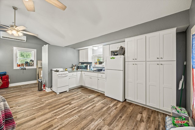kitchen featuring white appliances, ceiling fan, a wall unit AC, light wood-style floors, and lofted ceiling