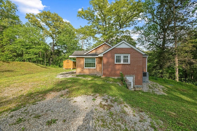 back of house with a yard, a storage unit, and an outdoor structure