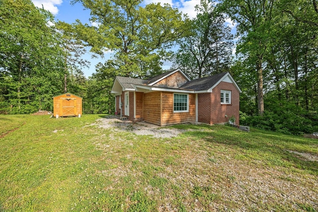 rear view of property featuring a storage unit, a yard, and an outdoor structure