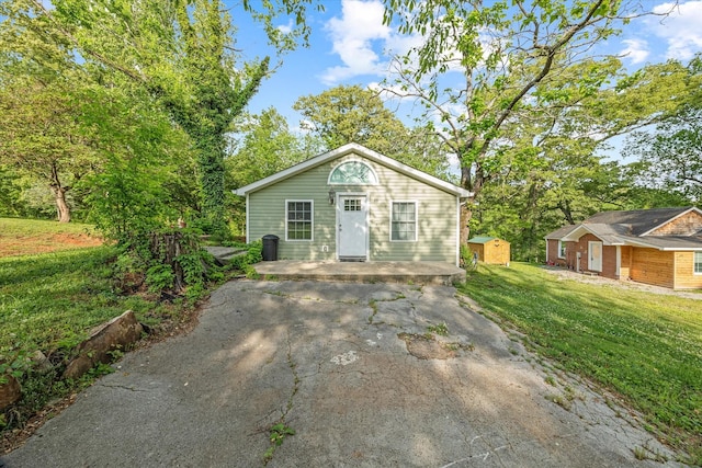 view of front of home featuring a front lawn and an outdoor structure
