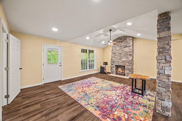 living area featuring a ceiling fan, a fireplace, wood finished floors, vaulted ceiling, and ornate columns