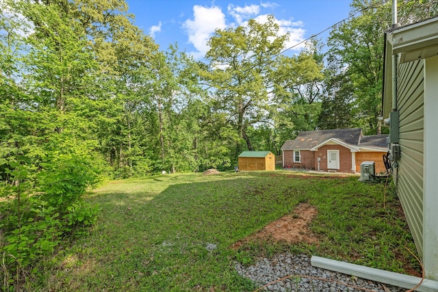 view of grassy yard featuring a storage unit and an outdoor structure