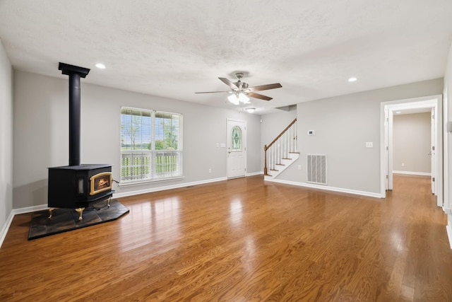 2907 York Rd, Pleasant View, TN 37146 - unfurnished living room featuring a wood stove, a ceiling fan, wood finished floors, baseboards, and recessed lighting