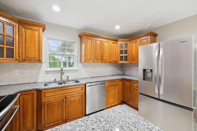 2907 York Rd, Pleasant View, TN 37146 - kitchen featuring appliances with stainless steel finishes, a sink, brown cabinets, light stone counters, and recessed lighting