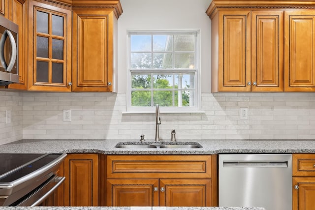 2907 York Rd, Pleasant View, TN 37146 - kitchen featuring appliances with stainless steel finishes, a sink, brown cabinetry, and light stone countertops