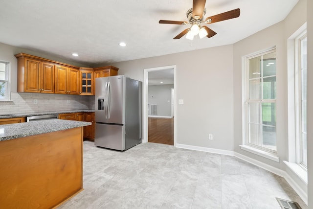 2907 York Rd, Pleasant View, TN 37146 - kitchen with appliances with stainless steel finishes, brown cabinets, a ceiling fan, light stone counters, and glass insert cabinets