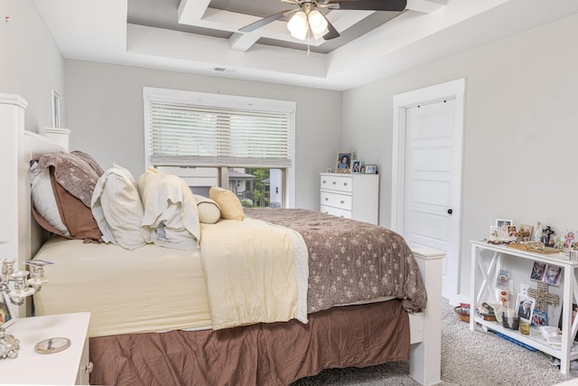 bedroom featuring a ceiling fan, a tray ceiling, and carpet