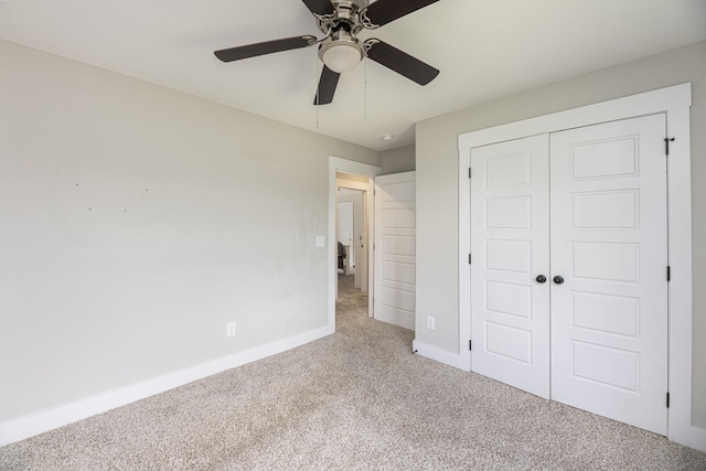 unfurnished bedroom with carpet floors, a closet, baseboards, and a ceiling fan